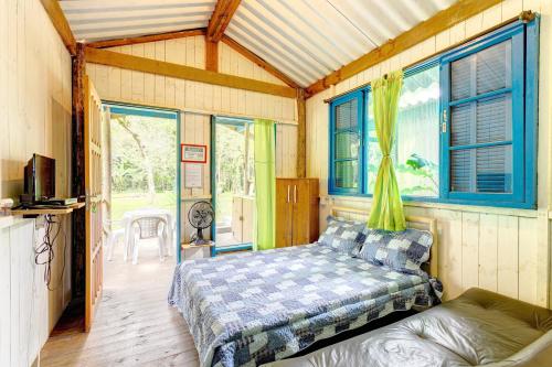a bedroom with a bed and a couch and windows at Bintang Bangalos in Camburi
