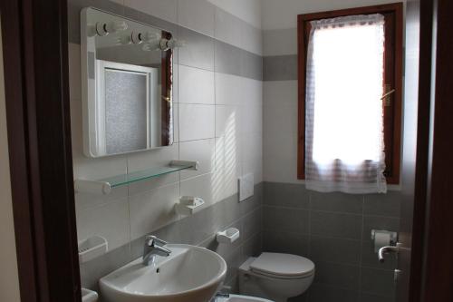 a bathroom with a sink and a toilet and a window at Casa Matilde in Capoliveri