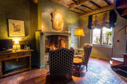 a living room with a fireplace and a table and chairs at B&B Canal Deluxe in Bruges