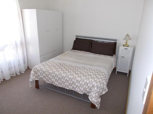 um quarto com uma cama e uma mesa de cabeceira em Costa Plenti Southend BnB em Southend