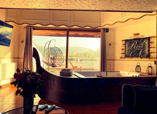 フォルバックにあるLe Rêve d'une Nuit suite Veniseの窓の前にバスタブが付く広い客室です。