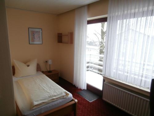 a bedroom with a bed and a large window at Aktivpension Regenbogen in Willingen