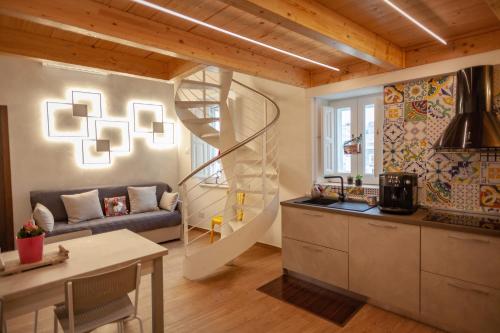 a kitchen and a living room with a spiral staircase at Casa Adelina nel Centro dei Sassi in Matera