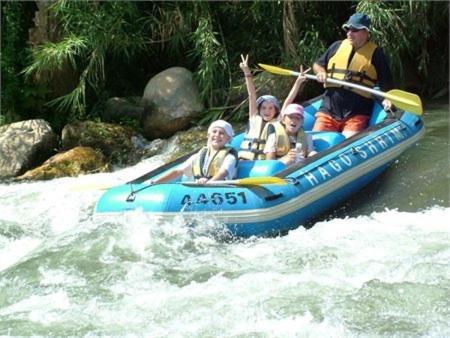 a group of people in a raft on a river at Rothschild Galilee Hospitality in Hagoshrim