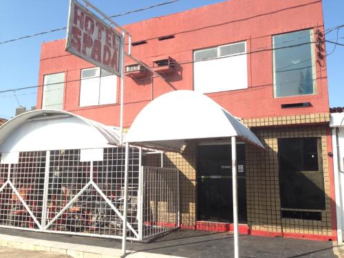 einem roten Backsteingebäude mit einem weißen Zelt davor in der Unterkunft Hotel Spada in Belém