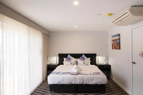 Un pat sau paturi într-o cameră la ODYSSEY APOLLO BAY
