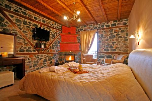 a bedroom with a bed in a room with a fireplace at Patriko Mountain Chalet in Palaios Agios Athanasios