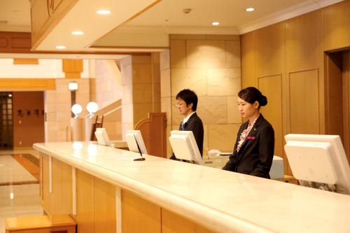 two women standing at a counter in an office at ANA Crowne Plaza Chitose by IHG in Chitose