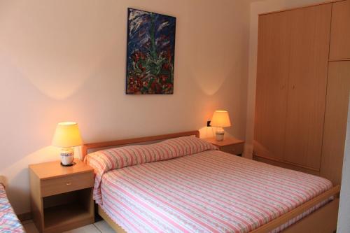 a small bedroom with a bed and two lamps at Casa Matilde in Capoliveri