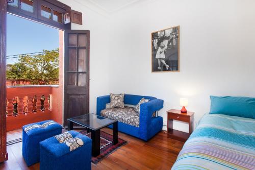 a living room with a blue couch and a chair at Italia Suite in Santiago