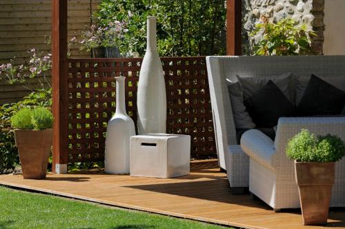 a patio with a couch and vases and a table at La Locanda Del Grop in Tavagnacco