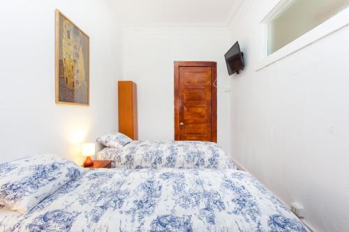 two twin beds in a room with a tv at Italia Suite in Santiago