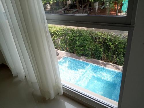 a view of a swimming pool through a window at Color House Santa Marta in Santa Marta