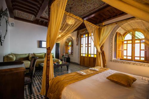 1 dormitorio con 1 cama y sala de estar en Palais Houyam, en Fez