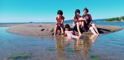 a group of children sitting on the beach at D-Rima Homestay Ruteng in Ruteng