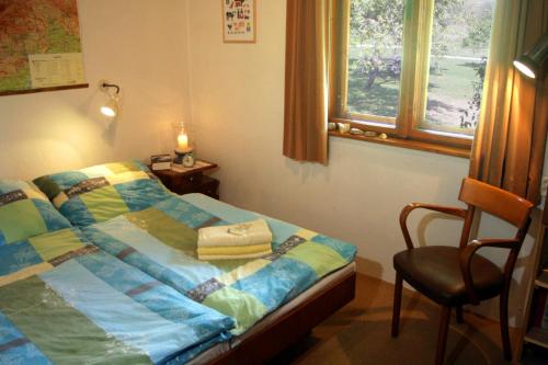 1 dormitorio con 1 cama, 1 silla y 1 ventana en Apartment at Sedliacky Dvor - Brezno, en Brezno