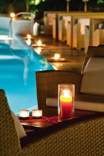 a candle sitting on a table next to a pool at Grand Hotel Excelsior Vittoria in Sorrento