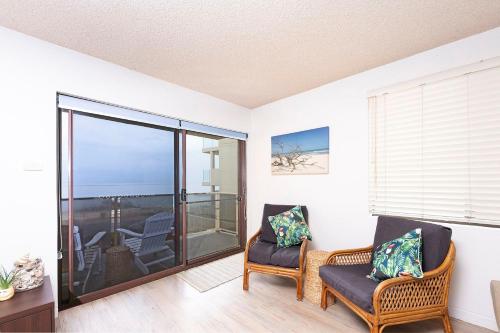 a living room with two chairs and a balcony at Hibiscus Unit 4, 24 North St, Forster in Forster
