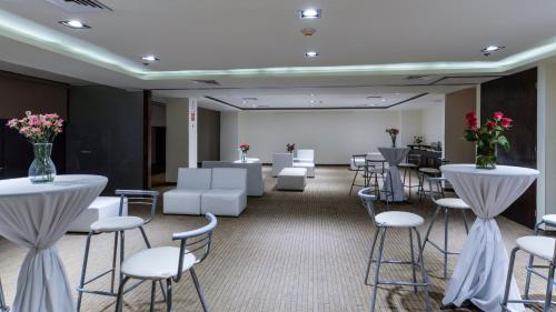 a room with white chairs and tables and flowers at Holiday Inn Express Culiacan by IHG in Culiacán