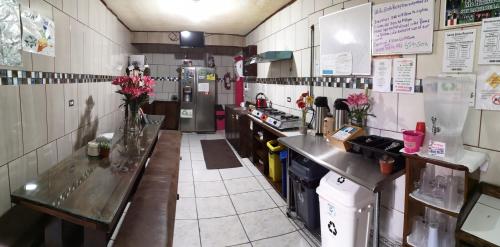 a kitchen with two long tables in a restaurant at Hotel & Hostel Sloth Backpackers in Monteverde Costa Rica