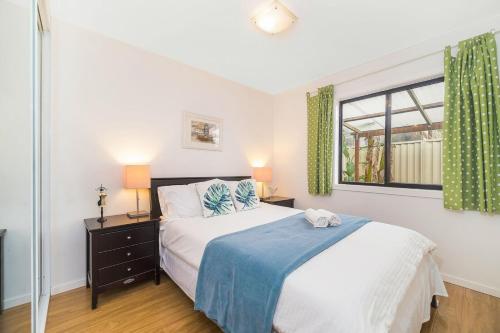Habitación blanca con cama y ventana en 3 Bedrooms Holiday Home Near Sydney Airport, en Sídney