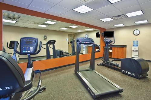 a gym with treadmills and ellipticals in front of a mirror at Holiday Inn Express and Suites Pittsburgh West Mifflin by IHG in West Mifflin