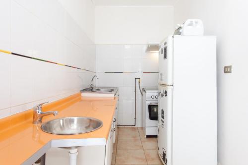 a small kitchen with a sink and a refrigerator at Italia Suite in Santiago