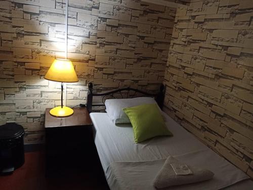 a bedroom with a bed with a lamp and a brick wall at Airport Travelodge Manila in Manila