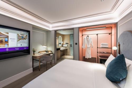 a bedroom with a bed and a dressing room at Mercure Fuzhou Downtown in Fuzhou