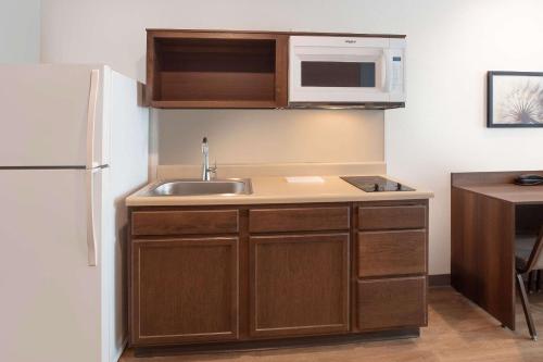 a kitchen with a sink and a white refrigerator at Wood Spring Suites Washington DC East Arena Drive in Hyattsville