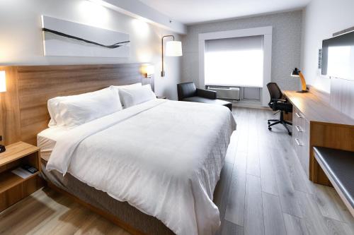 a hotel room with a large bed and a desk at Holiday Inn Express & Suites - Trois Rivieres Ouest by IHG in Trois-Rivières