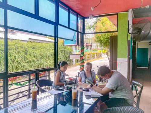 a group of people sitting at a table in a restaurant at 2 Home in Chalong 