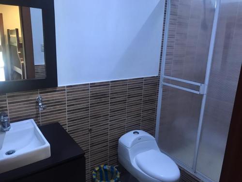 a bathroom with a toilet and a sink and a shower at The Heights in Montañita in Montañita