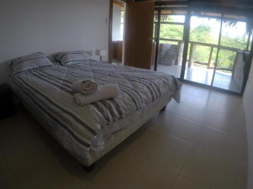a bedroom with a bed with two towels on it at The Heights in Montañita in Montañita