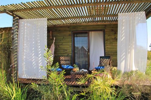 a porch of a house with a table and chairs at Angelo in Punta Del Diablo