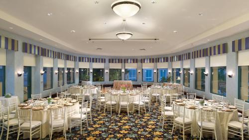 a banquet hall with white tables and chairs at Crowne Plaza Cabana Hotel by IHG in Palo Alto