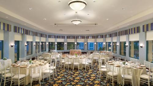 un salón de banquetes con mesas y sillas blancas en Crowne Plaza Cabana Hotel, an IHG Hotel, en Palo Alto