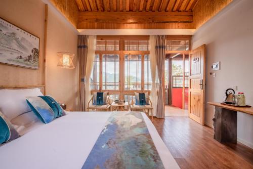a bedroom with a large bed and a large window at Floral Tengchong Mountain Residence in Tengchong