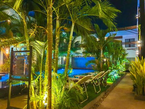 a resort with a pool and palm trees at night at Central Corner d'Angkor in Siem Reap