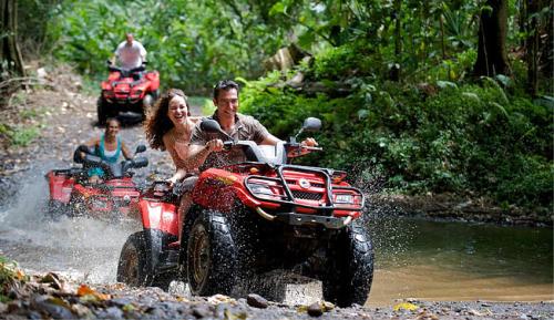a man and woman riding on a four wheeler in the water at Central Corner d'Angkor in Siem Reap