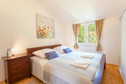 Un dormitorio con una cama grande y una ventana en Villa Tonci - comfortable & surrounded by nature en Tučepi
