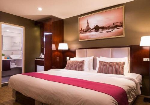 a hotel room with a large bed in a room at Ratchada Point Hotel in Bangkok