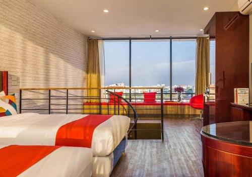 a hotel room with a bed and a large window at Ratchada Point Hotel in Bangkok