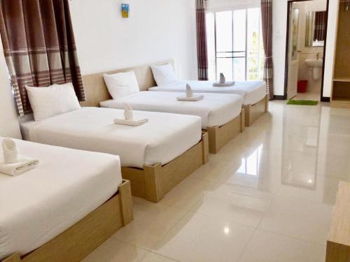 a row of four beds in a room at BanKhun in Nakhon Ratchasima