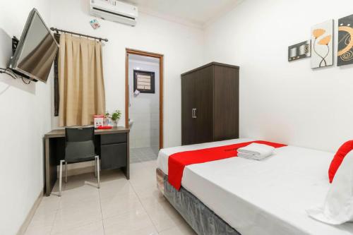 a bedroom with a desk and a bed and a deskablish at RedDoorz Plus near Trisakti University in Jakarta