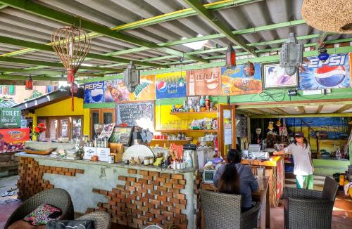 um restaurante com pessoas sentadas num balcão numa loja em Sawasdeepai River Resort em Pai