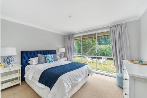 a bedroom with a bed and a large window at Lilyview Cottage - Robertson in Robertson