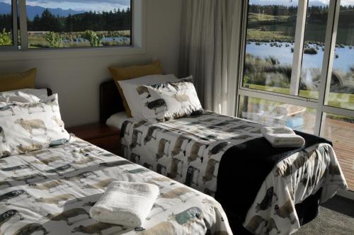 two beds in a room with a window at Cottage 45° South in Te Anau