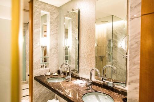 a bathroom with two sinks and a large mirror at Hyatt Regency Dongguan in Dongguan