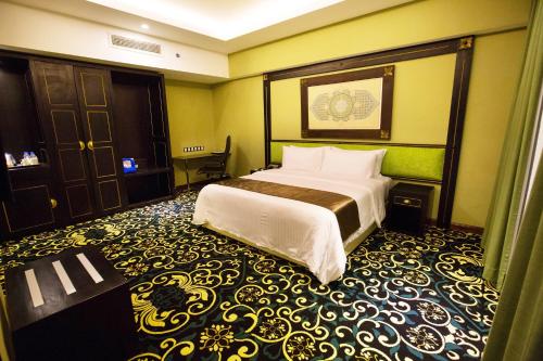 Un pat sau paturi într-o cameră la Mudzaffar Hotel
